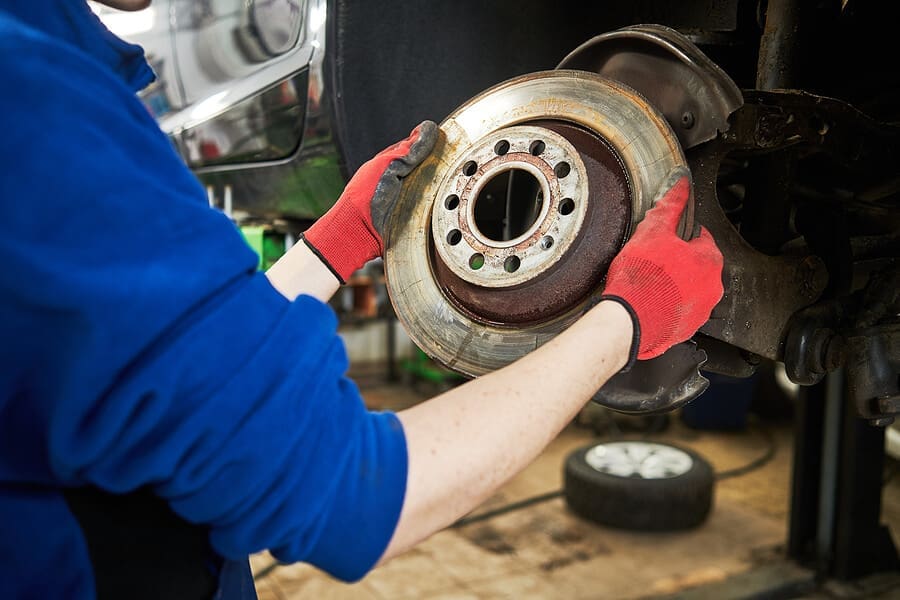 Auto technician servicing brakes on a vehicle at Accelerate Auto Repair in Rowlett TX