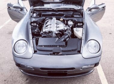 Image of a silver porsche with hood up exposing the engine that came into Accelerate Auto Repair in Rowlett Tx for services